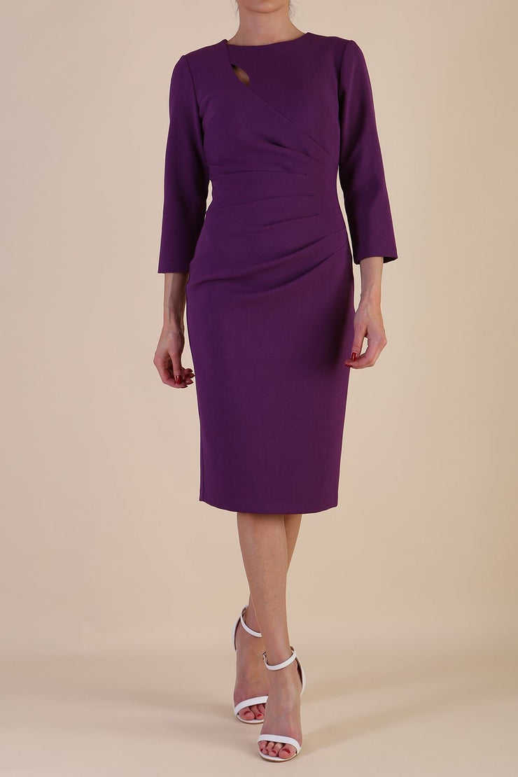 model is wearing diva catwalk miracle pencil dress with keyhole detail on a side of the front panel and gathering detail on a side or bodice panel with sleeves in Imperial Purple colour front