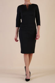 Model wearing the Diva Daphne ¾ Sleeved dress with pleat detail across the hips and ¾ sleeve length in black front