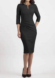 brunette model wearing seed diva catwalk milton sleeved pencil dress with a rounded neckline with a split in the middle in black front