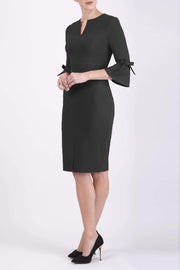 blonde model wearing diva catwalk zoe 3 4 sleeve formal dress with a split rounded neckline and split on skirt in black colour front