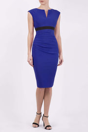 brunette model wearing diva catwalk nadia sleeveless pencil dress in cobalt blue colour with a contrasting black band and exposed zip at the back with a rounded neckline with a slit  in the middle front