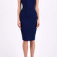 brunette model wearing diva catwalk beyonce pencil fitted dress with high neckline without sleeves with a wide band and pleating across the tummy area with a crossed detail neckline in navy blue  front