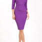 model wearing diva catwalk york pencil-skirt dress with sleeves and rounded folded collar and plearing across the tummy area in purple colour front