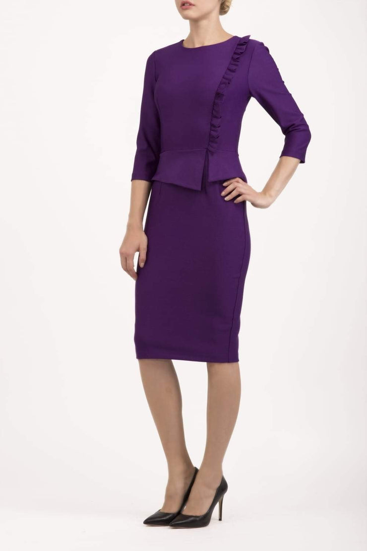 Brunette Model is wearing a three quarter sleeve couture seed pencil dress frill side detail by Diva Catwalk in purple front