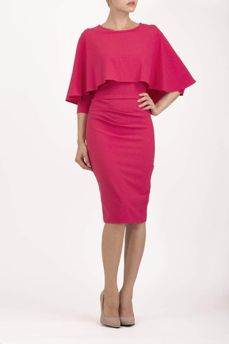 model wearing diva catwalk lizanne pencil-skirt dress with an attached wide cape detail and 3 4 sleeves in colour honeysuckle pink front