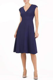 model wearing diva catwalk rochelle swing skirt a line dress without sleeves with a low v neck in navy front