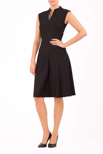 Brunette Model is wearing a sleeveless swing high neck dress in black by Diva Catwalk front