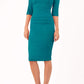 model is wearing diva catwalk pinhoe pencil dress with sleeved and high neckline with a keyhole detail in the middle and pleating across the tummy area in mosaic blue front