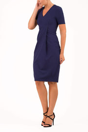 brunette model wearing diva catwalk tregony a-line dress with lowered v-neckline in oxford blue and short sleeves front