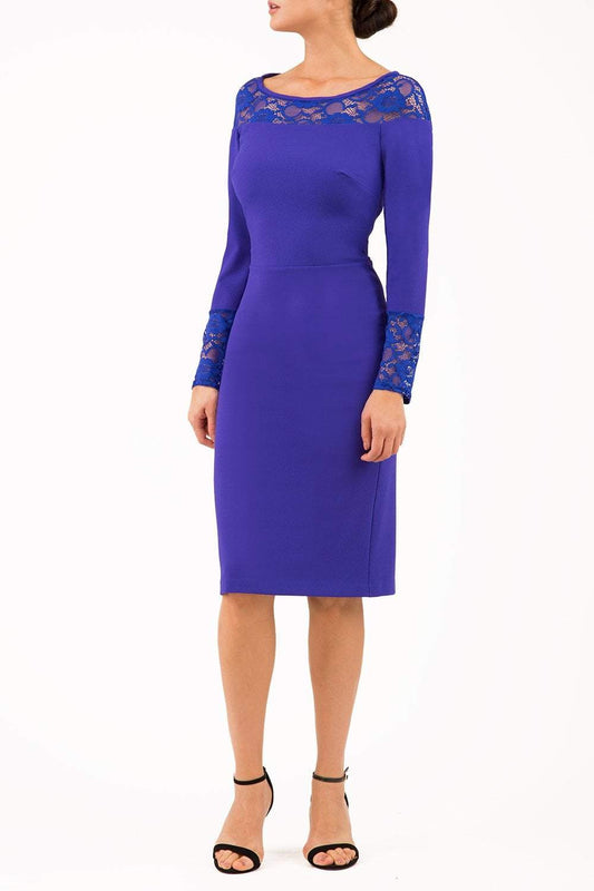 brunette model wearing diva catwalk blue lace pencil dress with long sleeves and rounded lace neckline with the lace covering shoulders front