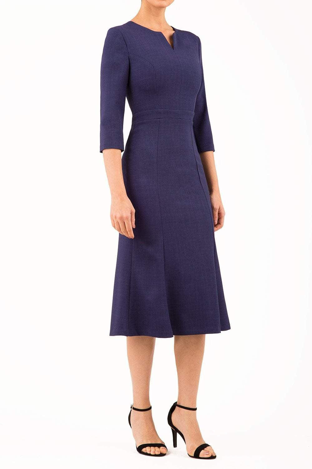 blonde model is wearing diva catwalk senne midaxi sleeved dress with fishtail and rounded neckline with a slit in the middle in navy front