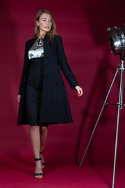 brunette model wearing diva catwalk couture fine raquella coat with buttons across the front and long sleeves with high neck and pockets in black colour front  Edit alt text