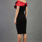 blonde model wearing diva catwalk samantha off shoulder pencil dress with satin red bow detail with a diamante brooch in black back