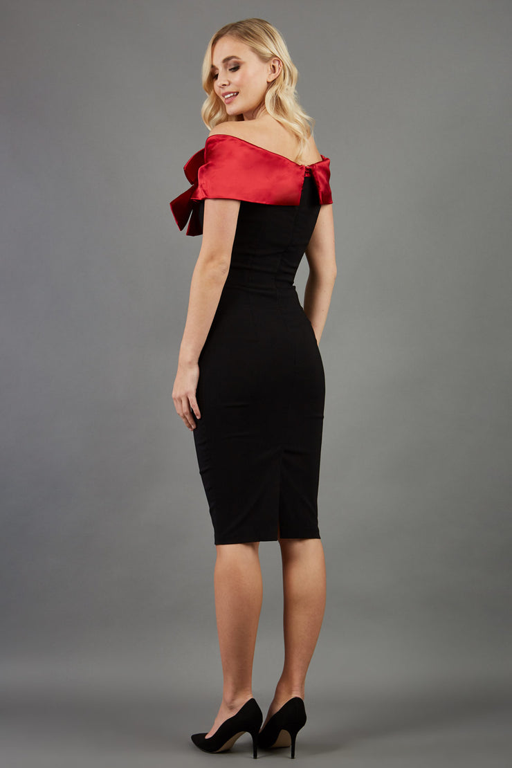 blonde model wearing diva catwalk samantha off shoulder pencil dress with satin red bow detail with a diamante brooch in black back