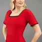 blonde model wearing seed albany contrasted pencil-skirt dress with short sleeves and pleating across the tummy with low square neckline and contrasted detail finishing in red front