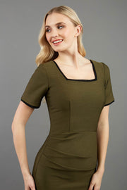 blonde model wearing seed albany contrasted pencil-skirt dress with short sleeves and pleating across the tummy with low square neckline and contrasted detail finishing in olive green front