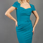 blonde model is wearing diva catwalk seed bonnie pencil skirt dress with cap sleeves and sweetheart neckline with pleating across the tummy in colour harbour blue green front