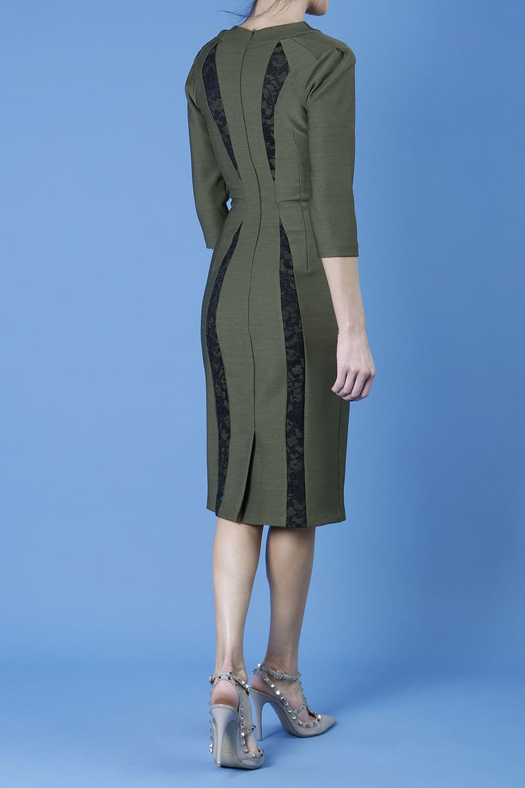 model wearing seed bertie dress with sleeves and rounded neckline with lace details pointing towards the band in olive green back