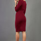 model wearing diva catwalk donna pencil dress in burgundy colour with wide band and sleeves and rounded neckline with low split in back