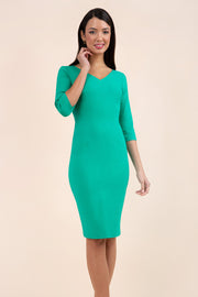 brunette model wearing diva catwalk natalie pencil-skirt dress with sleeves and v-neckline in emerald green front