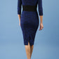 model is wearing diva catwalk stamford pencil dress with low v-neck and wide contrasting band in circle cobalt blue back