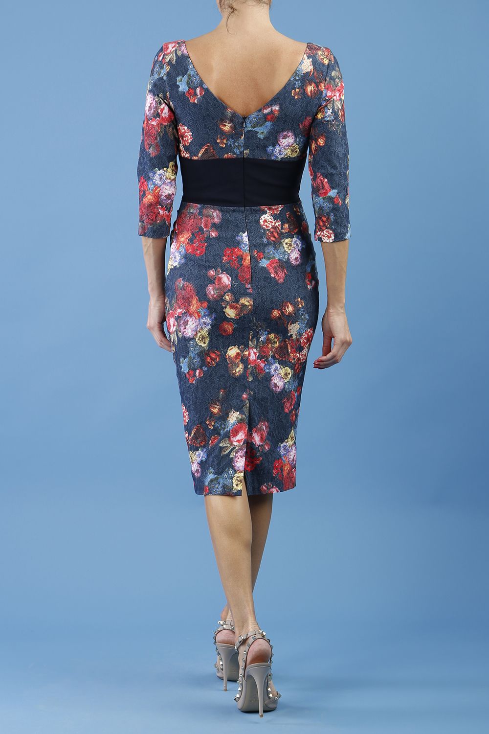 model is wearing diva catwalk stamford pencil dress with low v-neck and wide contrasting band in circle hidcote floral back