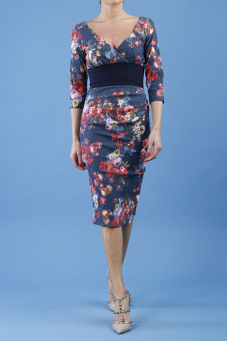 model is wearing diva catwalk stamford pencil dress with low v-neck and wide contrasting band in circle hidcote floral front