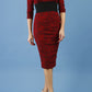 model is wearing diva catwalk stamford pencil dress with low v-neck and wide contrasting band in circle red front