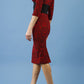 model is wearing diva catwalk stamford pencil dress with low v-neck and wide contrasting band in circle red front