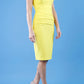 model wearing diva catwalk daphne sleeveless blazing yellow pencil dress with rounded neckline with split in the middle in front
