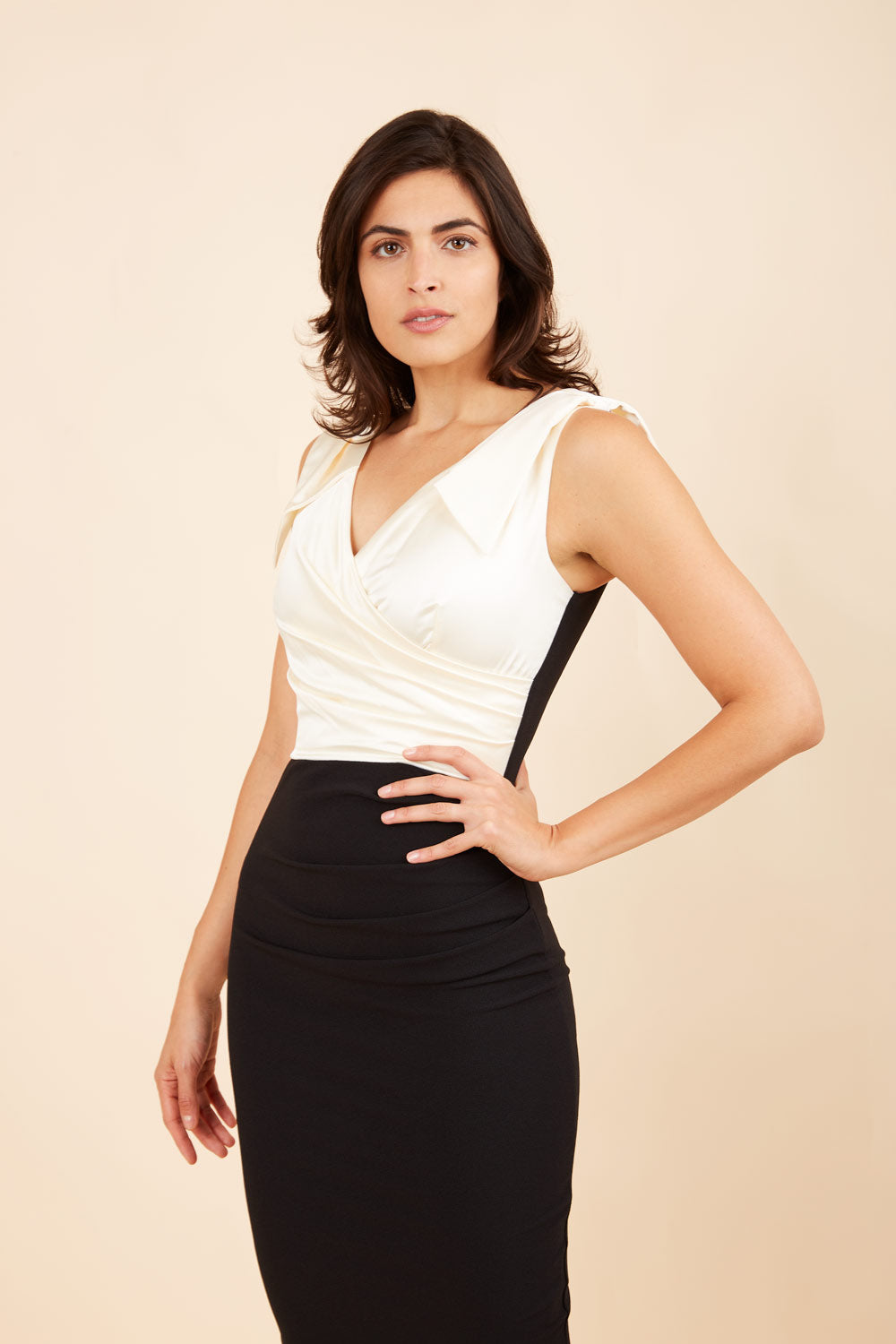 Model wearing the Diva Broadway Satin dress with satin bodice to front and pleating at the front in cream and black back image