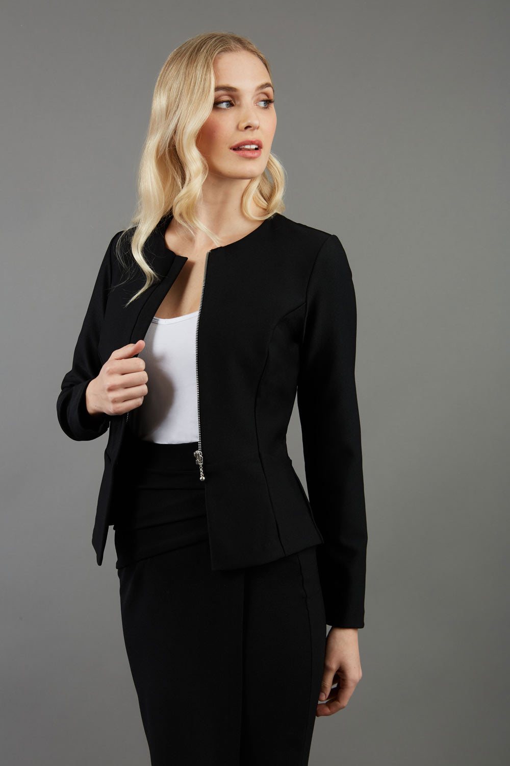 blonde model wearing seed diva catwalk dawlish jacket with long sleeved and zip detail at the front paired with dawlish pencil-skirt front