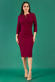 Model wearing the Diva Daphne ¾ Sleeved dress with pleat detail across the hips and ¾ sleeve length in blissful burgundy front
