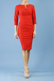 Model wearing Diva catwalk Daphne ¾ Sleeved pencil-skirt dress with pleat detail across the hips and ¾ sleeve length in burnt orange front