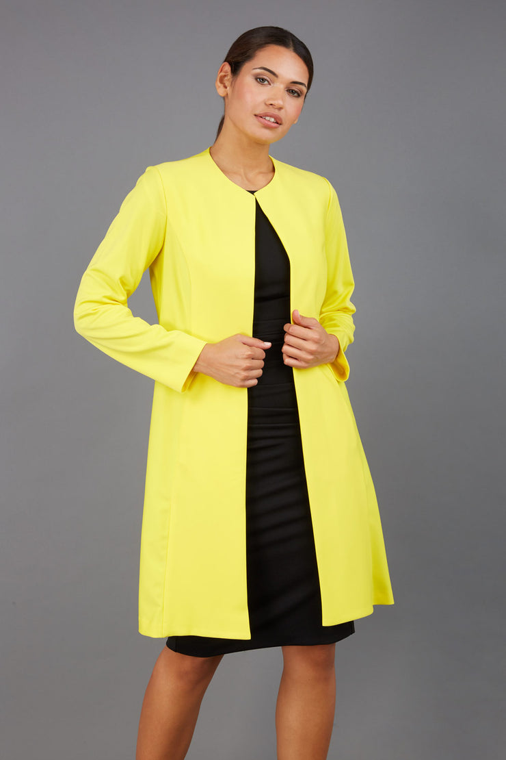 model wearing diva catwalk yellow coat with long sleeves and a belt front
