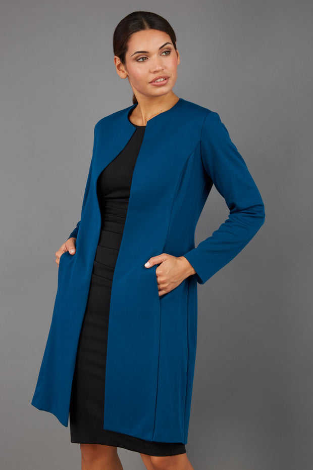 model wearing diva catwalk teal coat with long sleeves and a belt front