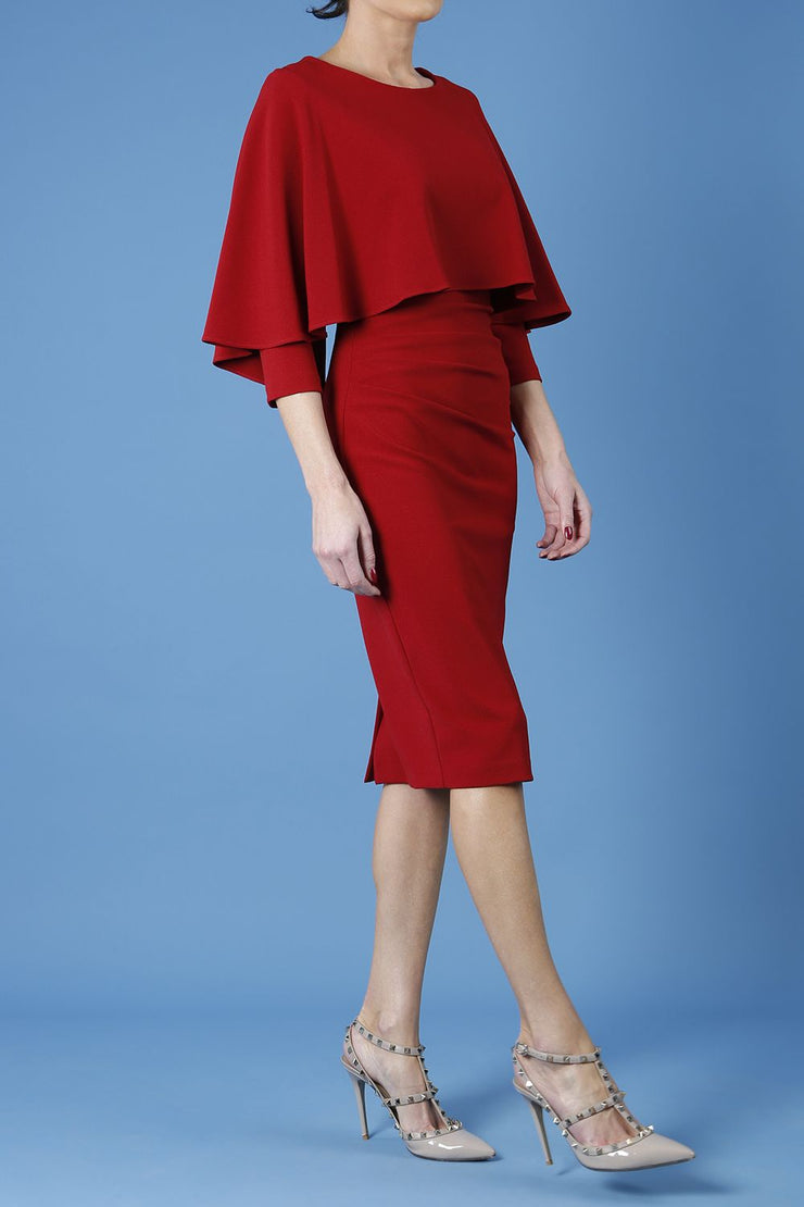 model wearing diva catwalk lizanne pencil-skirt dress with an attached wide cape detail and 3 4 sleeves in colour rosewood red front