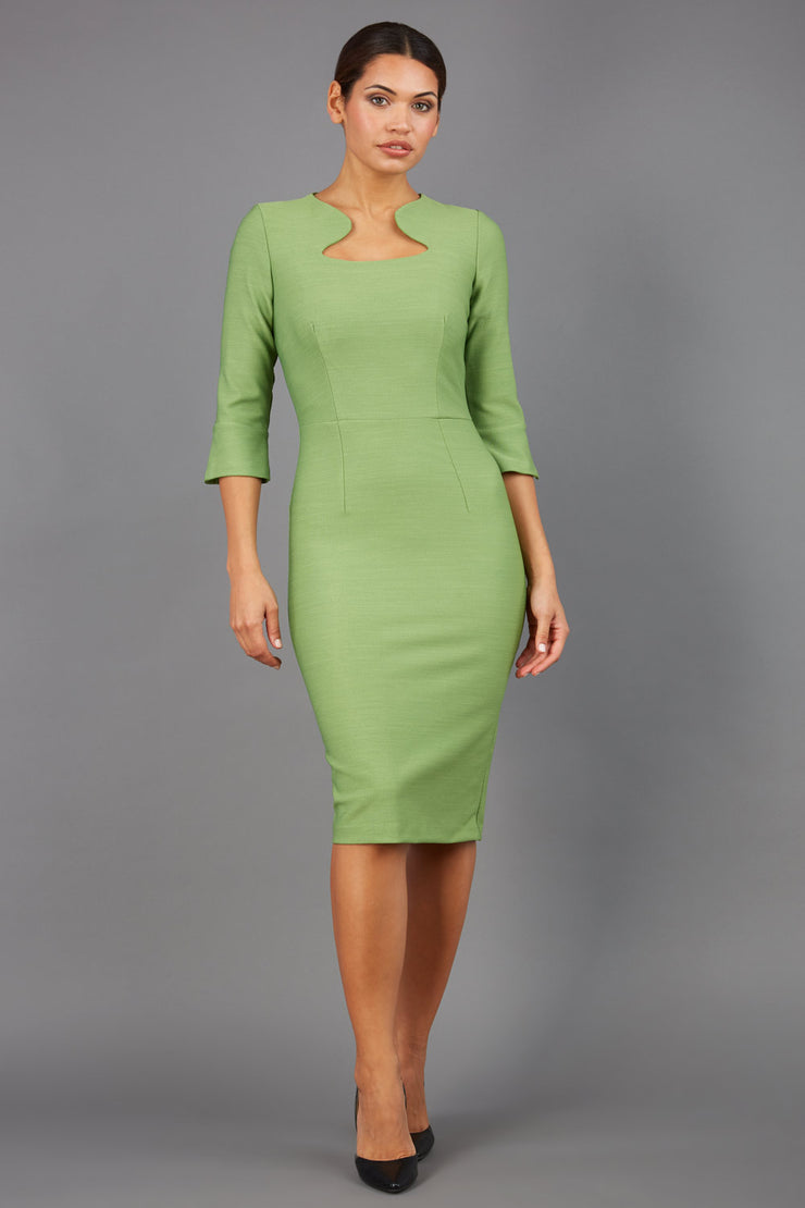 Brunette model is wearing couture stretch seed pencil bell 3/4 sleeve pencil dress by diva catwalk in citrus green front image