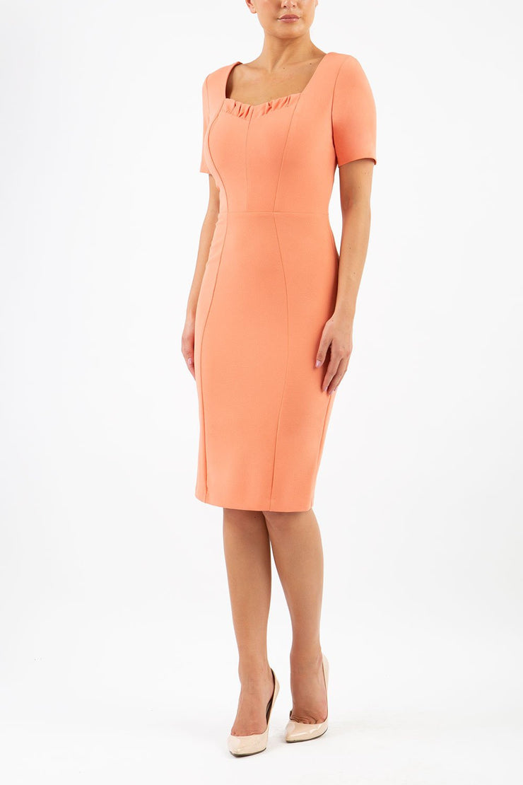 model wearing diva catwalk mitzi short sleeve pencil dress with square frilled neckline in dusty coral front 