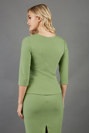 blonde model is wearing diva catwalk courtney sleeved topin colour aspen green back paired with green top 