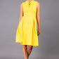 brunette model wearing diva catwalk oceana a-line swing skirt sleeveless dress with funnel neckline and tie detail in yellow front