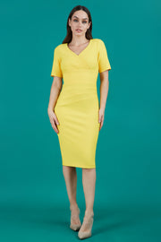 model is wearing diva catwalk seed barton short sleeve pencil dress with v-neck in daffodil yellow front 