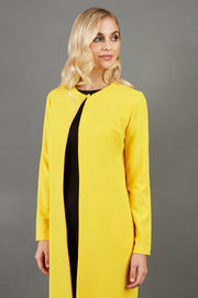 blonde model wearing the Diva Bliss Coat with round neckline in freesia yellow front image