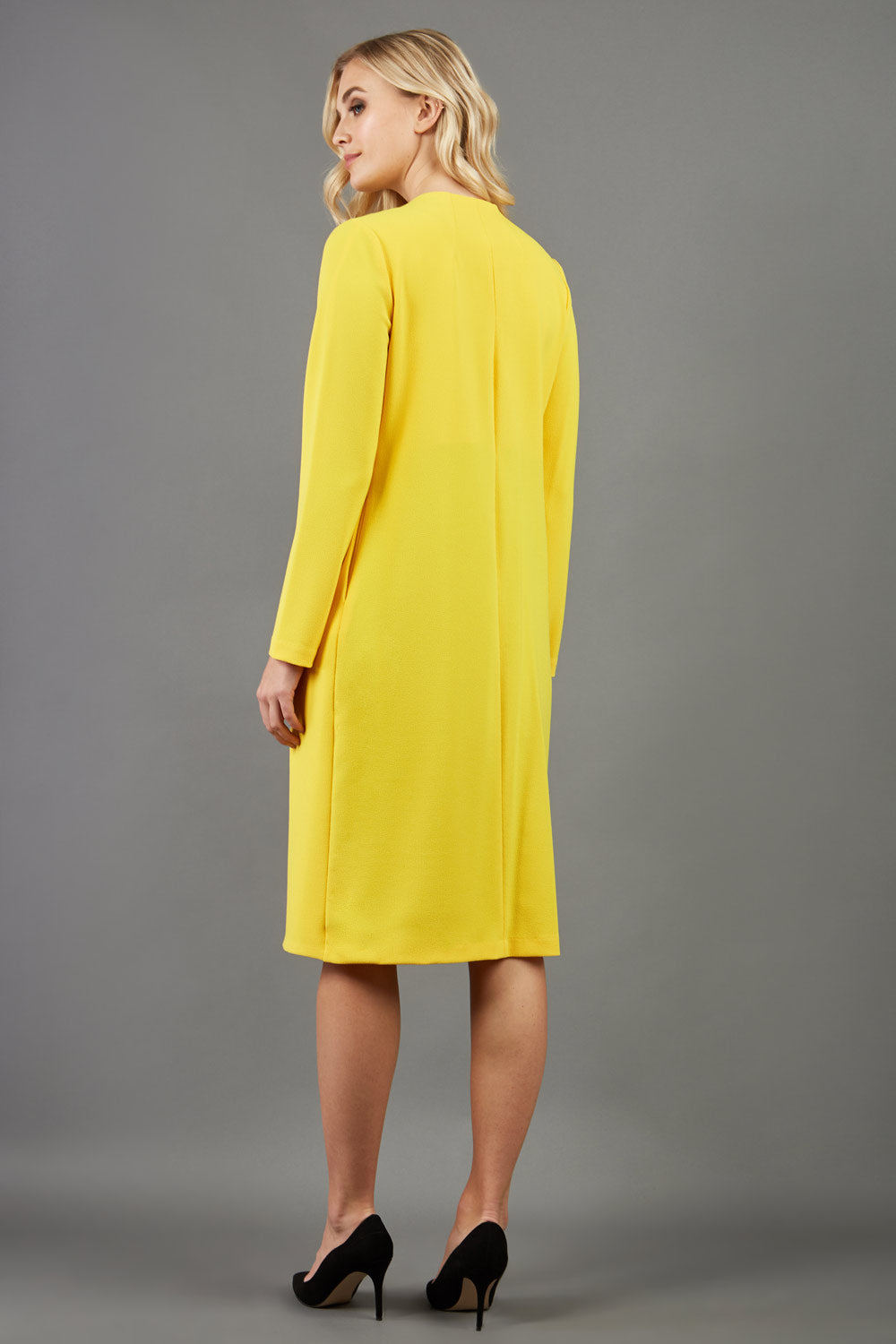 blonde model wearing the Diva Bliss Coat with round neckline in freesia yellow back image