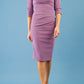 brunette model wearing diva catwalk best selling lydia pencil sleeved dress with slit at the neckline and pleating across the tummy in colour purple heart front