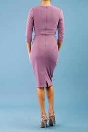 brunette model wearing diva catwalk best selling lydia pencil sleeved dress with slit at the neckline and pleating across the tummy in colour purple heart back