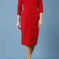 model is wearing diva catwalk seed holsworthy pencil dress with pleating on a tummy area and high neck with sleeves in cardinal red front