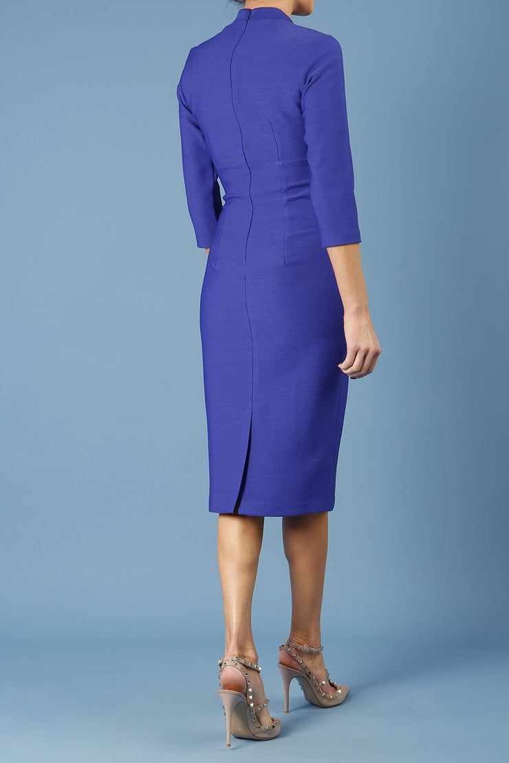 model is wearing diva catwalk seed holsworthy pencil dress with pleating on a tummy area and high neck with sleeves in palace blue back