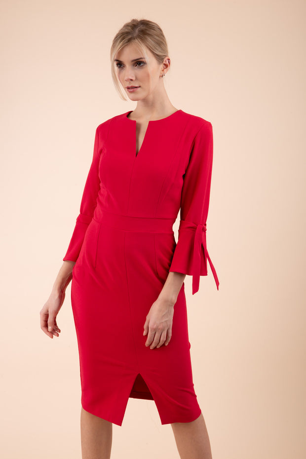 blonde model wearing diva catwalk zoe 3 4 sleeve formal dress with a split rounded neckline and split on skirt in ruby red colour front