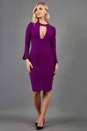 model is wearing diva catwalk fifi pencil skirt dress with three quarter flute sleeve and rounded neckline with a cut out at the front in purple  front image